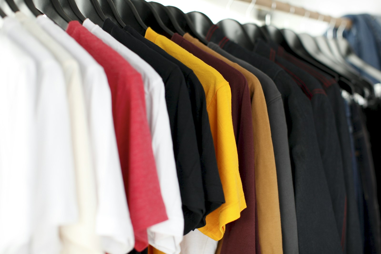 Custom embroidery and t-shirt printing in Upper Darby, PA Rack of custom printed and embroidered apparel in assorted colors at Delaware County Shirt Printing, Upper Darby PA