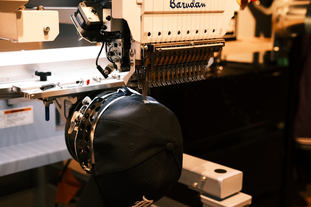 Custom Embroidery in Upper Darby, PA Multi-head commercial embroidery machine stitching a cap at Delaware County Shirt Printing, Upper Darby PA