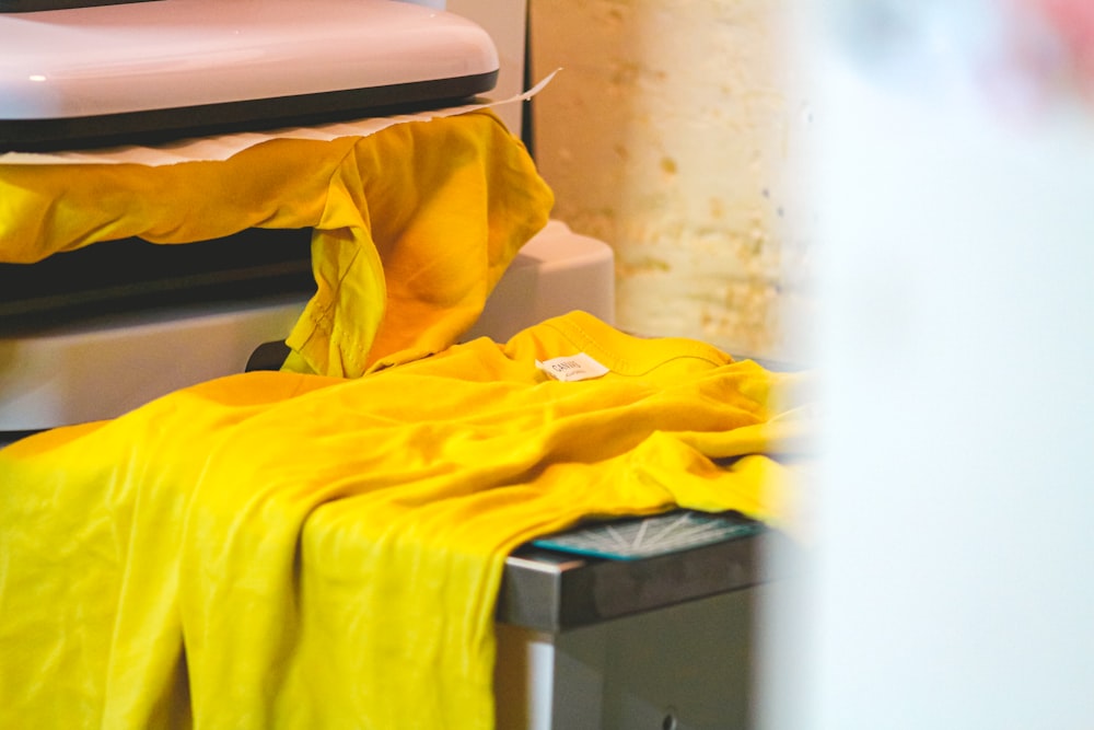 DTF Printing in Upper Darby, PA DTF transfer being heat-pressed onto a yellow t-shirt at Delaware County Shirt Printing, Upper Darby PA