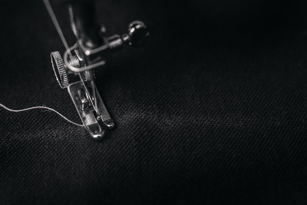 Embroidered Shirts in Upper Darby, PA Close-up of embroidery needle and thread stitching dark fabric at Delaware County Shirt Printing, Upper Darby PA
